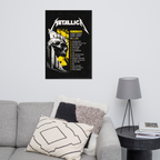 Metallica poster on a wall above a gray sofa with decorative pillows and a lamp.