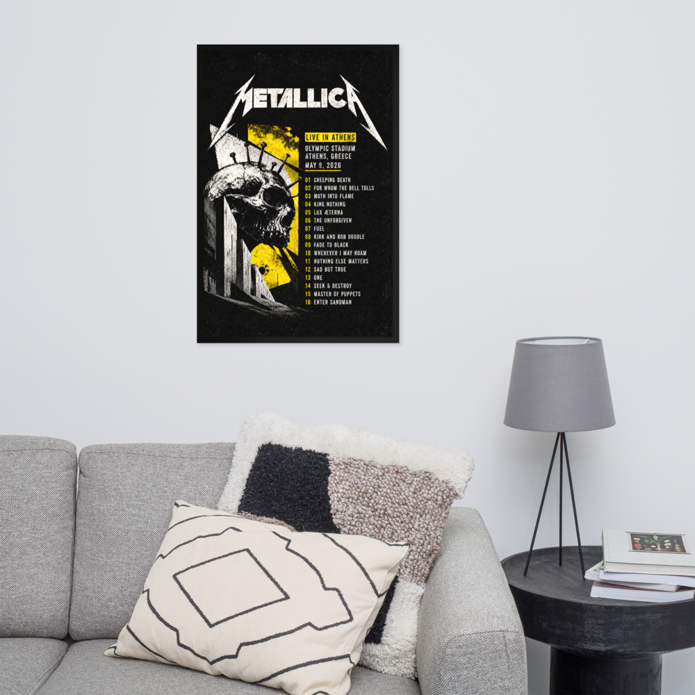 Metallica poster on a wall above a gray sofa with decorative pillows and a lamp.