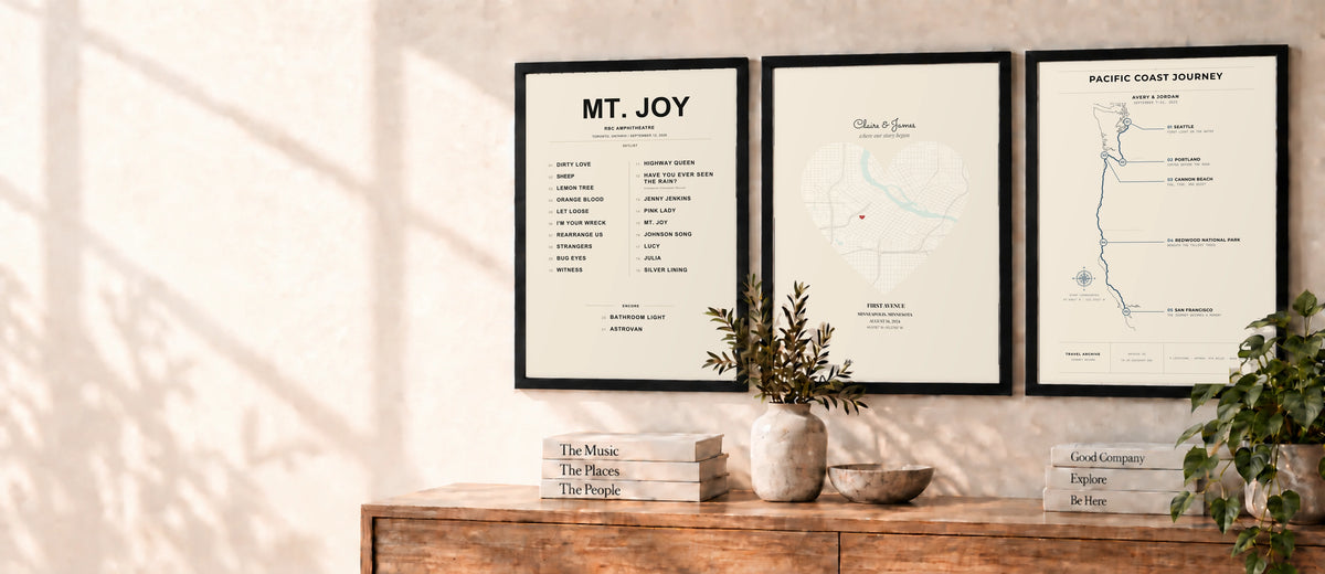 Concert, Love, and Travel Archive artwork in black frames above a wooden console