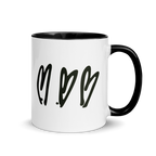 White mug with black interior, handle, and heart design on a white background